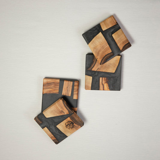 Four coasters made from wood and epoxy resin in the color gun powder