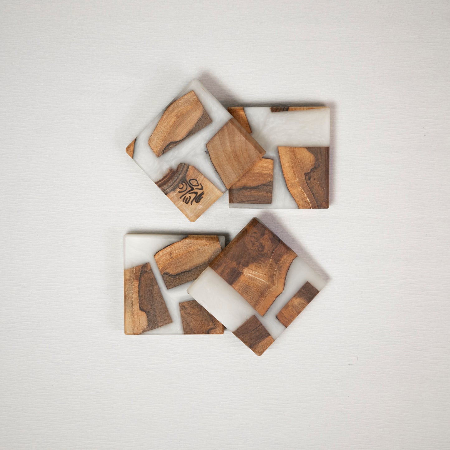 Four coasters made from wood and epoxy resin in the color nobel white