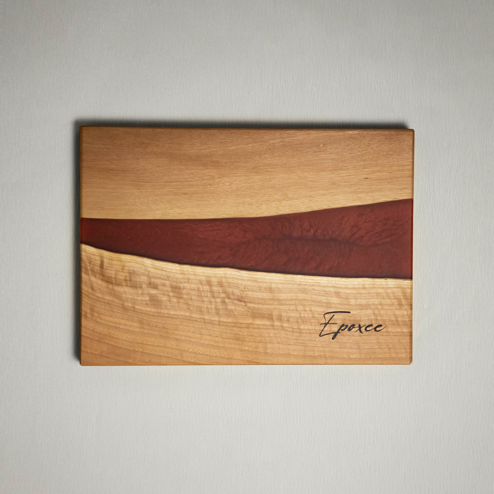 Serving board made from wood and epoxy resin in the color red orange