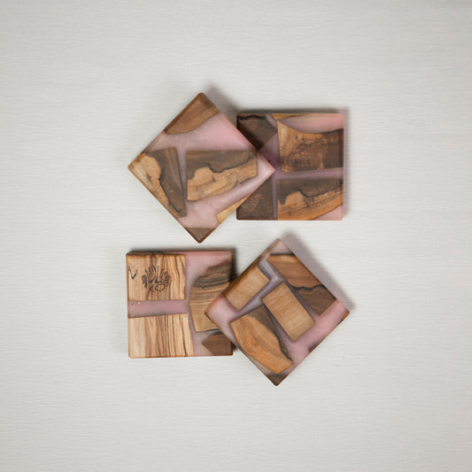 Four coasters made from wood and epoxy resin in the color rose quartz