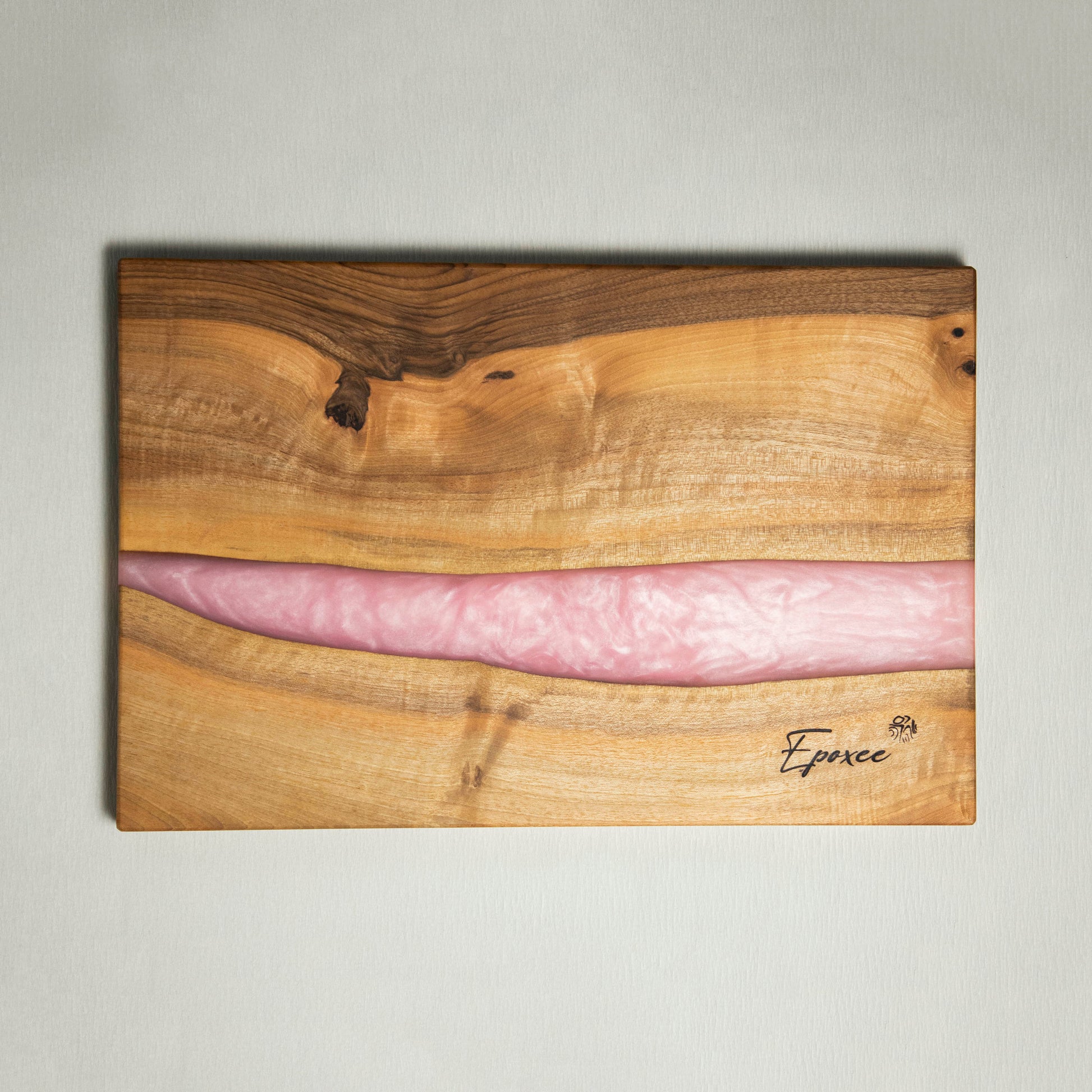 Serving board made from wood and epoxy resin in the color rose quartz