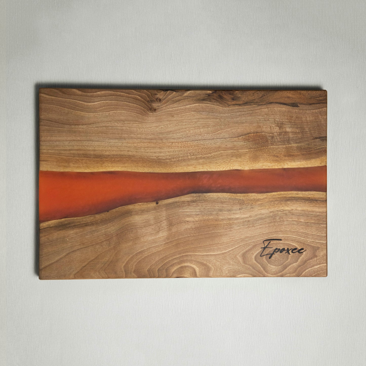 Serving board made from wood and epoxy resin in the color siena orange